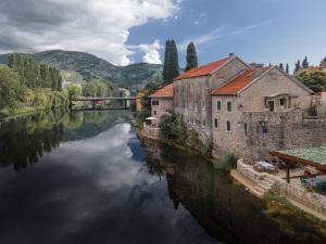 vistas a un río con edificios y un puente en Hotel Restoran Humsko, en Trebinje