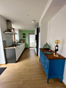 een keuken met een blauw eiland in het midden van een kamer bij Charmant et chaleureux gîte dans le vignoble in Sigolsheim