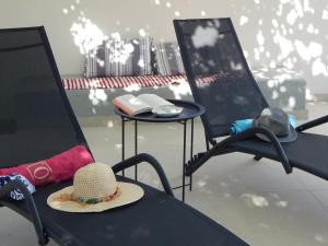 a hat sitting on a table with two chairs at Pervoli in Faliraki