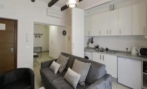 a living room with a couch and a kitchen at Apartamentos Plaza Nueva in Seville