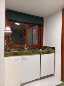 uma cozinha com um lavatório e um espelho em Monolocale a due minuti dal mare IUN R4225 em Marina di Portisco