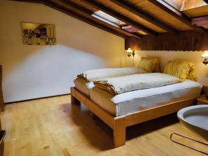 1 dormitorio con cama y lavamanos en Apartments Atlas, en Saas-Grund