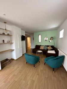 een woonkamer met een bank en 2 blauwe stoelen bij Charmant et chaleureux gîte dans le vignoble in Sigolsheim