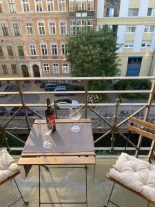 a table with two wine glasses and a bottle on a balcony at Innenstadt Refugium in ruhiger Wasserlage+Balkon in Leipzig