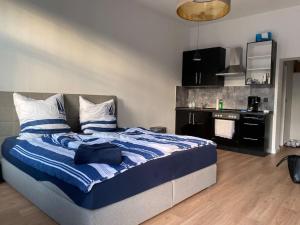 a bedroom with a bed with blue and white sheets at Innenstadt Refugium in ruhiger Wasserlage+Balkon in Leipzig