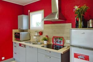 a kitchen with red walls and a white refrigerator at Baie du Mont Saint Michel / Gîte de la Vaquerie in Vains