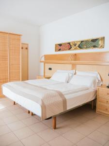 een slaapkamer met een groot bed met een houten hoofdeinde bij Hotel Bristol in Lido di Jesolo