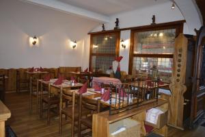 ヴェンゲンにあるスイス ロッジ ホテル ベルナーホフのテーブルと椅子と赤いナプキンを用意したレストラン