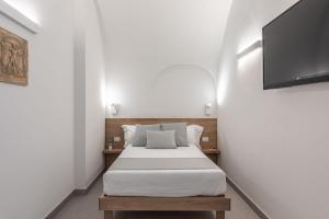 Schlafzimmer mit einem Bett und einem Flachbild-TV in der Unterkunft Dimora dei Celestini in Manfredonia