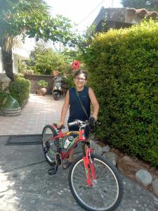 een vrouw zit op een rode fiets bij VILLA CORTESE in SantʼEufemia Lamezia