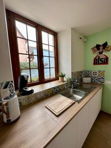 een keuken met een wastafel en een raam bij Charmant et chaleureux gîte dans le vignoble in Sigolsheim