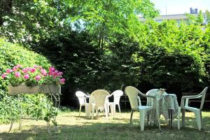 a group of chairs and tables in a yard with flowers at Hotel Flora in Bellaria-Igea Marina +25 photos