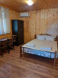 ein Schlafzimmer mit einem Bett mit einem Tisch und einem Tisch in der Unterkunft Комплекс Джулай Морнинг in Kiten