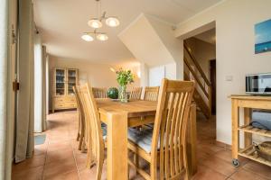 a dining room with a wooden table and chairs at Fischerhaus 309 in Rechlin