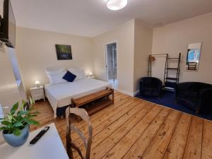 a bedroom with a bed and a wooden floor at Le Rodin Bazas in Bazas