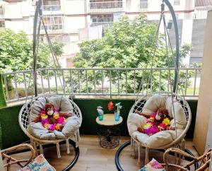 Wonder Rooms Nerja Guest House في نيرخا: وجود دميتين جالستين على كراسي في الشرفة