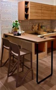 a kitchen with a island with two chairs and a sink at Casa vacanze San Francesco in Barletta