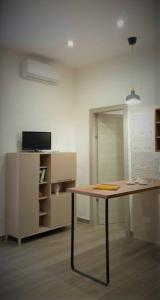 a room with a table and a tv in a room at Casa vacanze San Francesco in Barletta