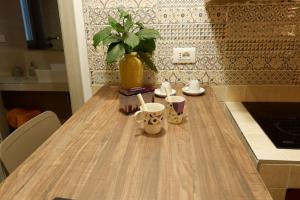 a wooden table with cups and a vase on it at Casa vacanze San Francesco in Barletta