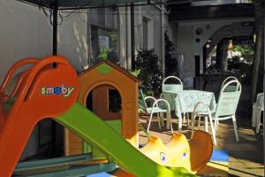 een speeltuin met een glijbaan en een tafel en stoelen bij Hotel Flora in Bellaria-Igea Marina