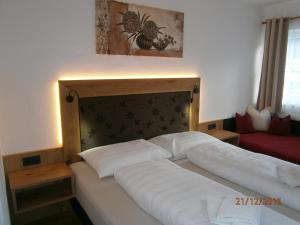ein Schlafzimmer mit einem großen Bett mit weißer Bettwäsche in der Unterkunft Appartements Schitter in Flachau