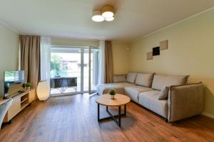 Kuressaare Pikk Apartment في كوريساري: غرفة معيشة مع أريكة وطاولة