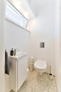 a bathroom with a toilet and a sink and a window at Kuressaare Pikk Apartment in Kuressaare