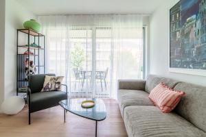 a living room with a couch and a glass table at Suite Parco Lago by Quokka 360 - Terraced flat close to Lido Locarno in Locarno