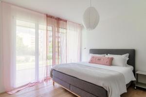 a bedroom with a bed and a large window at Suite Parco Lago by Quokka 360 - Terraced flat close to Lido Locarno in Locarno