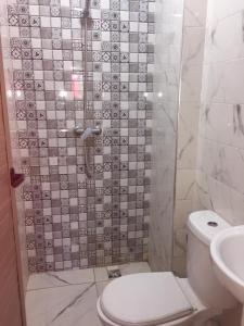 uma casa de banho com um chuveiro, um WC e um lavatório. em Sweet Room Airport 5 em Deroua