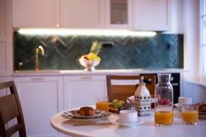 Apartments Allegra في سيني: طاولة مطبخ مع صحن من الطعام وعصير برتقال