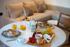 Apartments Allegra في سيني: طاولة عليها طعام ومشروبات للإفطار