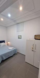 Cette chambre comprend un lit et un réfrigérateur. dans l'établissement La Maisonnette Turquoise, à Dar Mimoun Bey