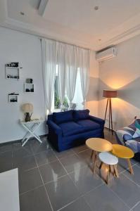 sala de estar con sofá azul y mesa en La Maisonnette Turquoise en Dar Mimoun Bey