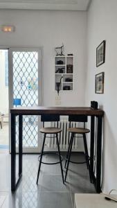 a desk in a room with two stools at La Maisonnette Turquoise in Dar Mimoun Bey