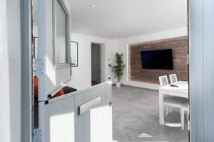 a living room with a television and a table and a desk at Stunning new 1 bed apartment in Marazion. in Marazion
