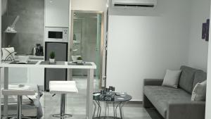 een woonkamer met een bank en een tafel en een keuken bij KM LUXURY APART DOWNTOWN in Heraklion
