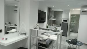 een witte badkamer met een wastafel en een spiegel bij KM LUXURY APART DOWNTOWN in Heraklion