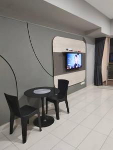 a living room with a table and chairs and a tv at We Stay Studio Room Aeropod Near Airport,KKCity,TgAru Beach-6Pax in Kota Kinabalu