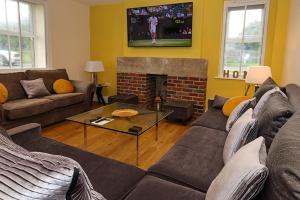 Bramall House Accommodation في Fewston: غرفة معيشة مع أريكة ومدفأة