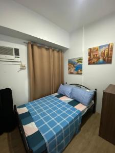 sypialnia z łóżkiem z niebieską kołdrą w obiekcie Anuva Suite ( Free Swimming Access) w mieście Manila