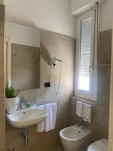a bathroom with a sink and a toilet and a window at Hotel Aquila in Castelfranco Emilia