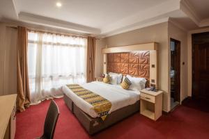 Postel nebo postele na pokoji v ubytování The Luke Hotel Cravers Thika