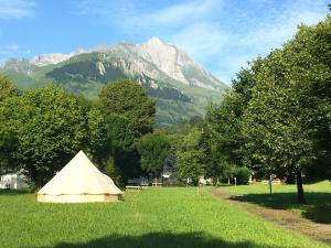 a tent in a field with a mountain in the background at Tentes Glamping au camping Le Gerrit à Marsous in Arrens-Marsous