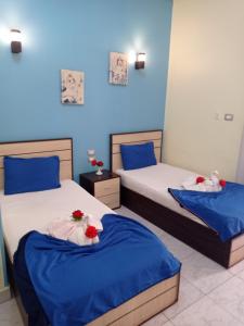 2 camas en una habitación con paredes azules en Hostgram Hotel en El Cairo