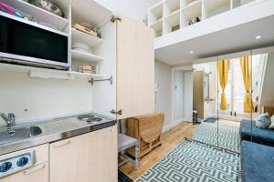 a kitchen with a sink and a tv in a room at Flat w/ terrace in Notting Hill in London