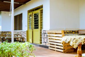 a yellow door on a house with a table and chairs at INZOZI AFRICA HOUSE B&B-Kimihurura in Kigali