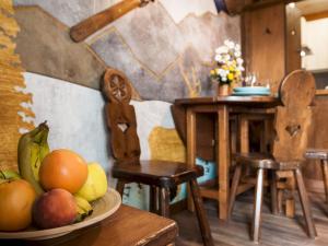 a table with a bowl of fruit on a plate at [Maska Home Cervinia] in Breuil-Cervinia