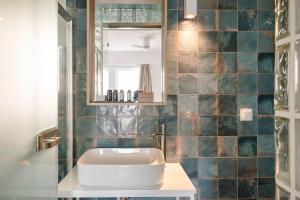 uma casa de banho com um lavatório e um espelho em The Blue em Skiathos