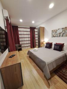 una camera da letto con un letto grande e tende rosse di B&S Accommodation Seafront Duplex Penthouse Marsascala, Malta a Marsaskala